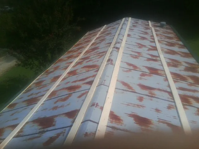 Rusted metal roof panels with new wood purlins before replacement — Storm Damage Roof Repair in Buncombe by Roofing Brothers