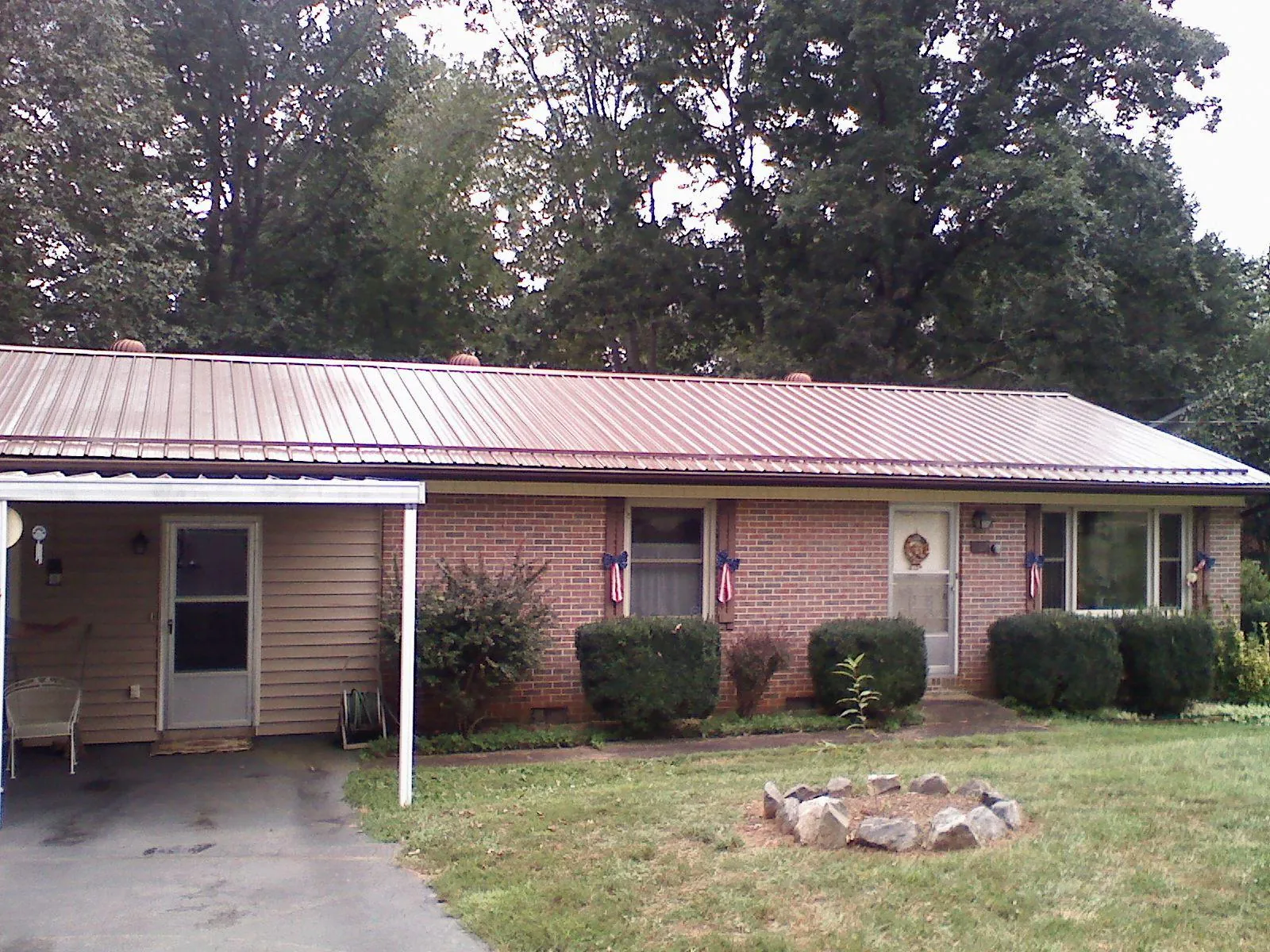 Bronze metal roof and carport on a brick ranch home — Roof Repair work by our crew in Buncombe